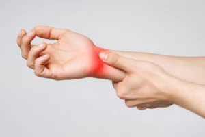 Person experiencing wrist pain and numbness associated with carpal tunnel syndrome and median nerve compression.