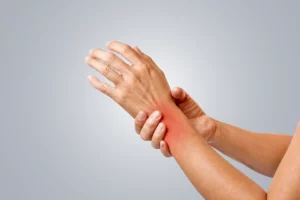 Person holding a painful wrist with visible inflammation and discomfort
