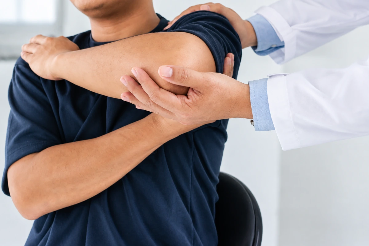 Lift your arm: Doctor examining a patient’s shoulder and arm movement